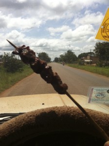 Fast food African style.  Vendors sell items like this delicious beef on a stick at roadside markets.  When a bus (or car) stops, they rush with their wares. 