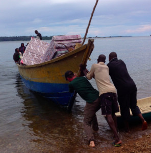 Team member JD Hull (on left) helps push off a delivery boat on Lake Victoria.