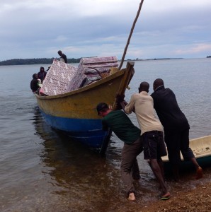 JD helps shove off the cargo boat on Lake Victoria.