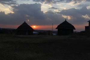 Africa is ancient and modern. Sunset over tukuls (huts) with cell phone tower.